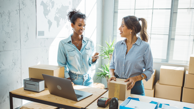 Two small business employees in an office reviewing onboarding paperwork during the Live Scan fingerprinting and background check process in California.