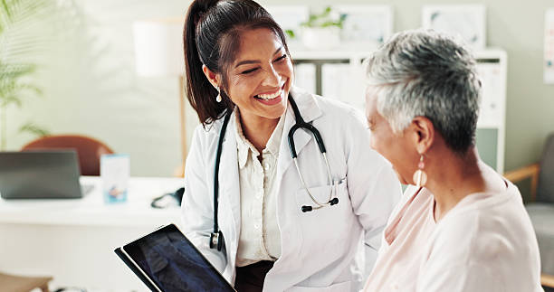 Two female healthcare clinicians reviewing a tablet together, representing Live Scan for healthcare employers screening clinical staff in California.